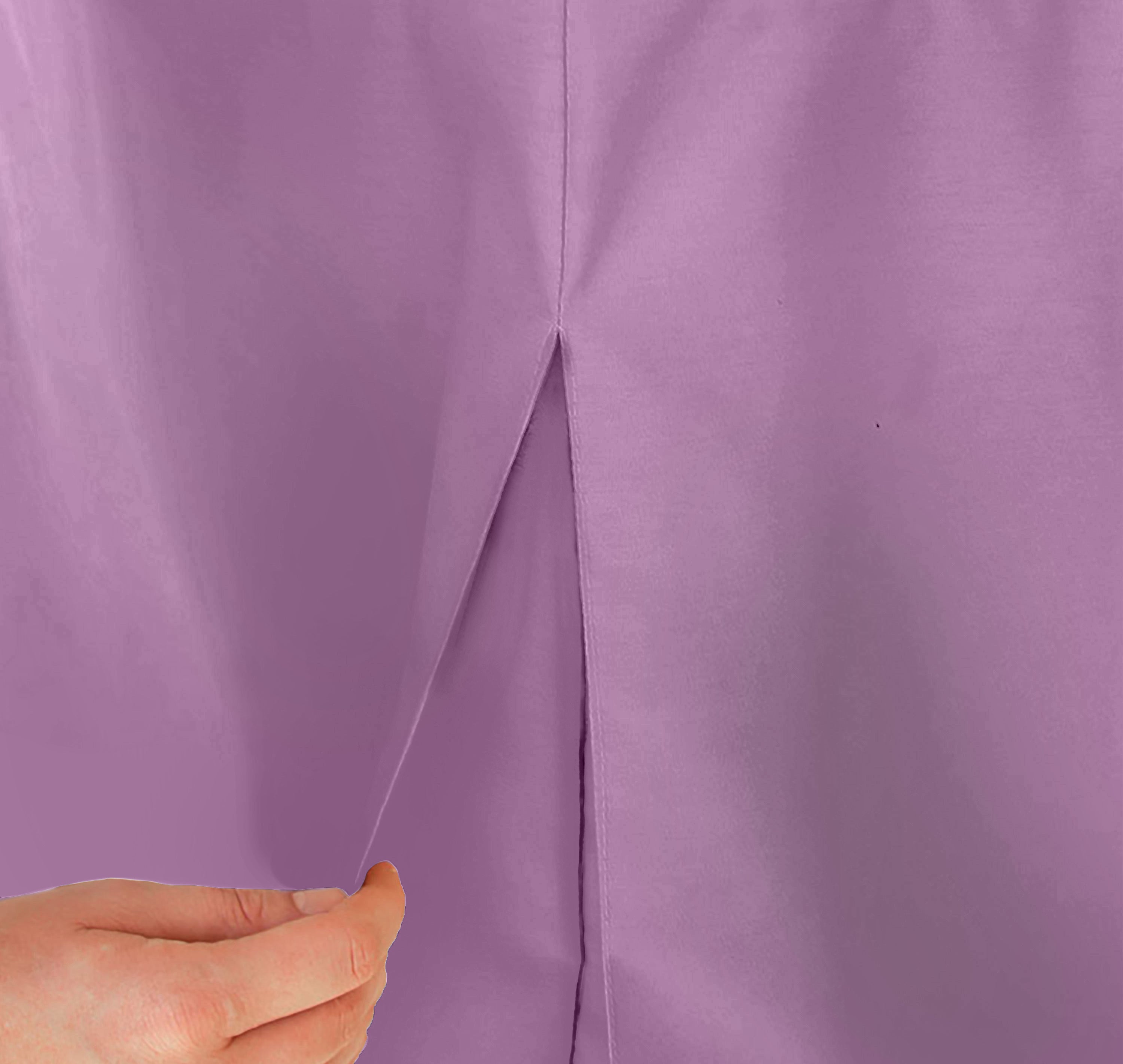 Close-up of a lavender table cover with a pleat, showing a hand holding the fabric.
