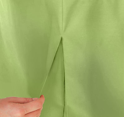 Close-up of a green table cover with a slit, being held by a hand.