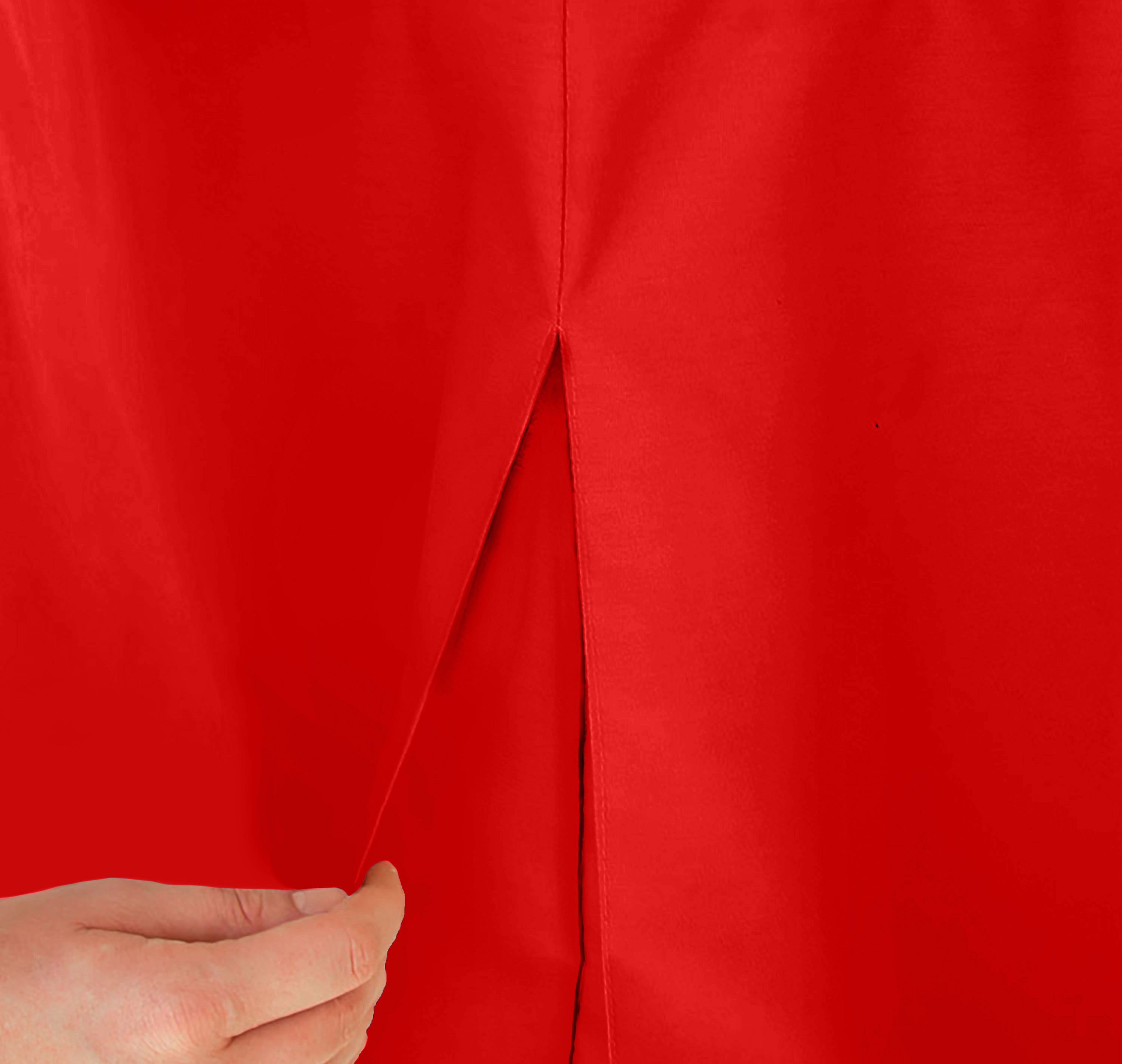 Close-up of a red table cover with a slit, being held by a hand.