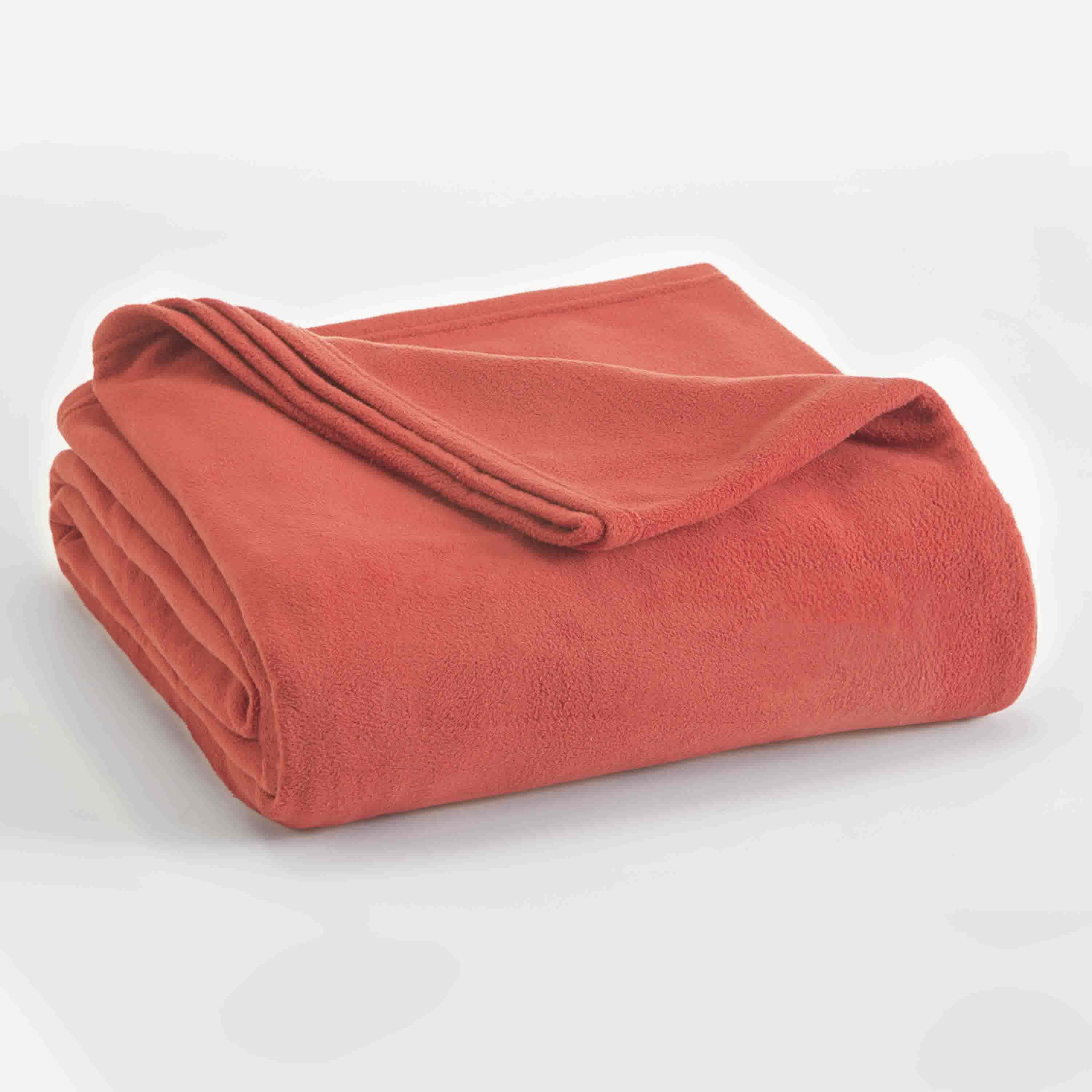 Coral micro fleece blanket folded with a smooth texture and a slightly rolled edge.