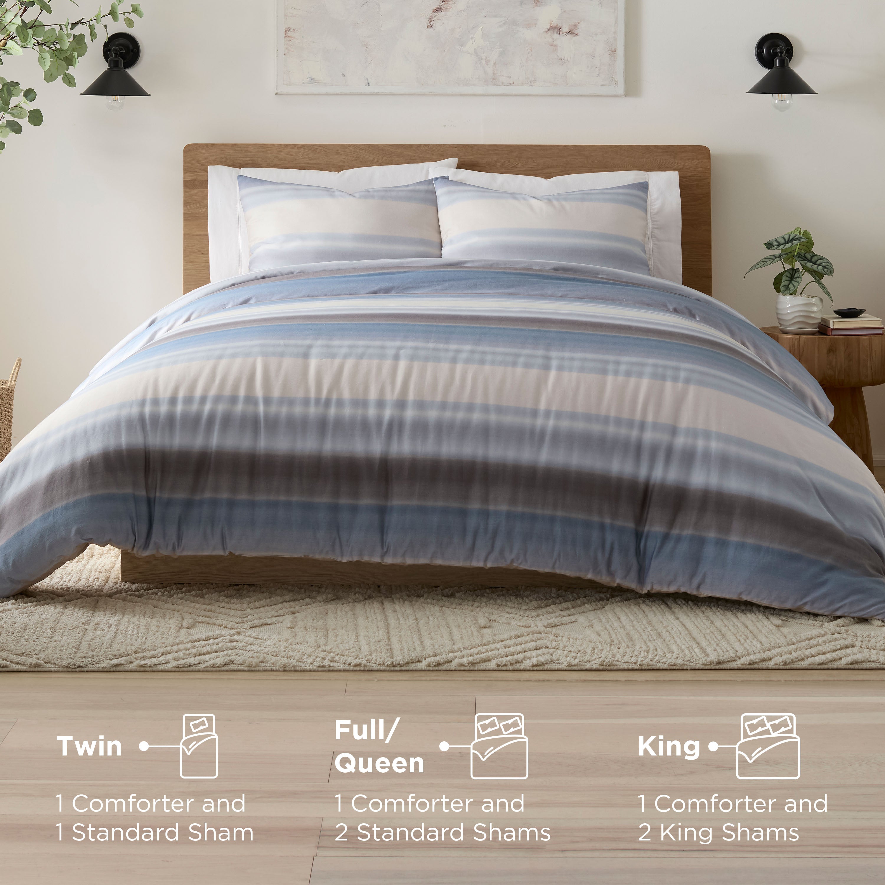 Comforter set featuring blue and beige stripes, displayed on a bed with two pillows and a nightstand beside it.