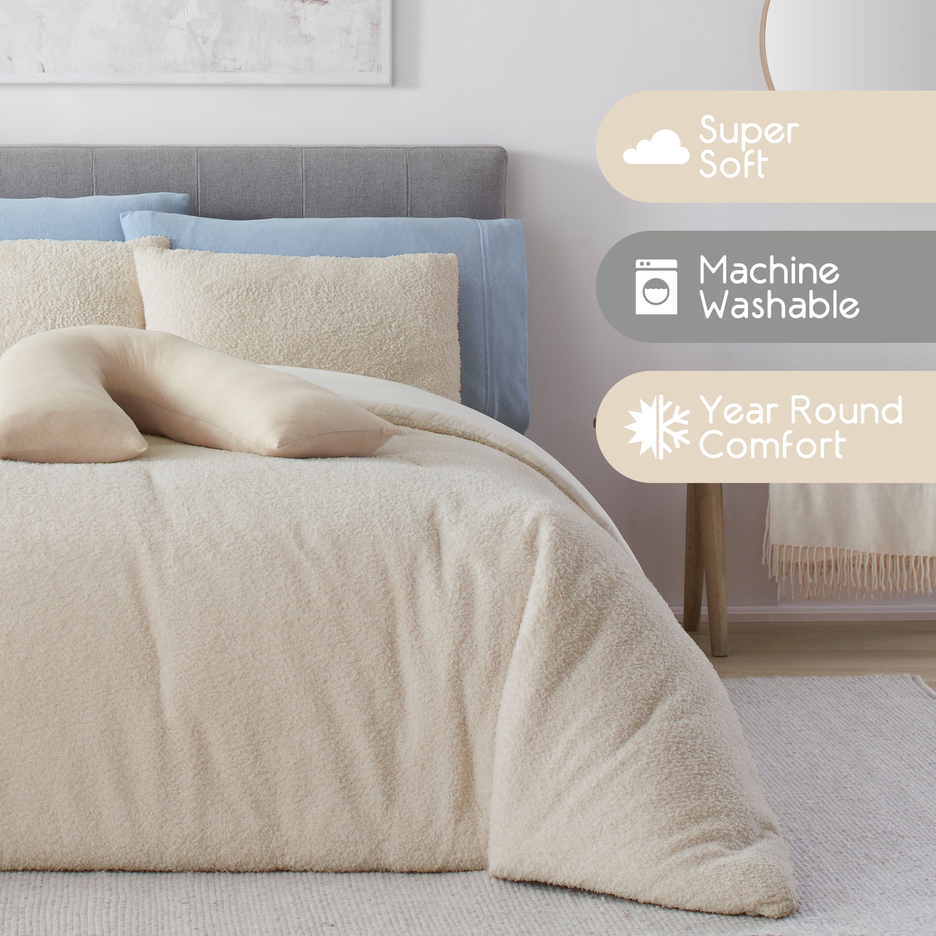 Cream-colored comforter set on a bed with gray and blue pillows, featuring a decorative body pillow.