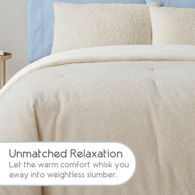Light beige comforter set with a soft, textured surface and matching pillows on a bed with a blue headboard.