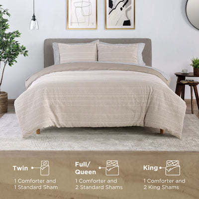 Comforter set displayed on a bed with two standard shams, featuring a textured beige design and a neutral backdrop.