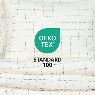 Coverlet set featuring a grid pattern in white with black lines, labeled with Oeko-Tex Standard 100 certification.