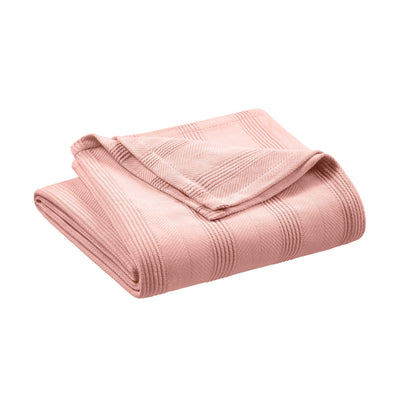 Folded cotton blanket in a soft pink color with textured stripes.