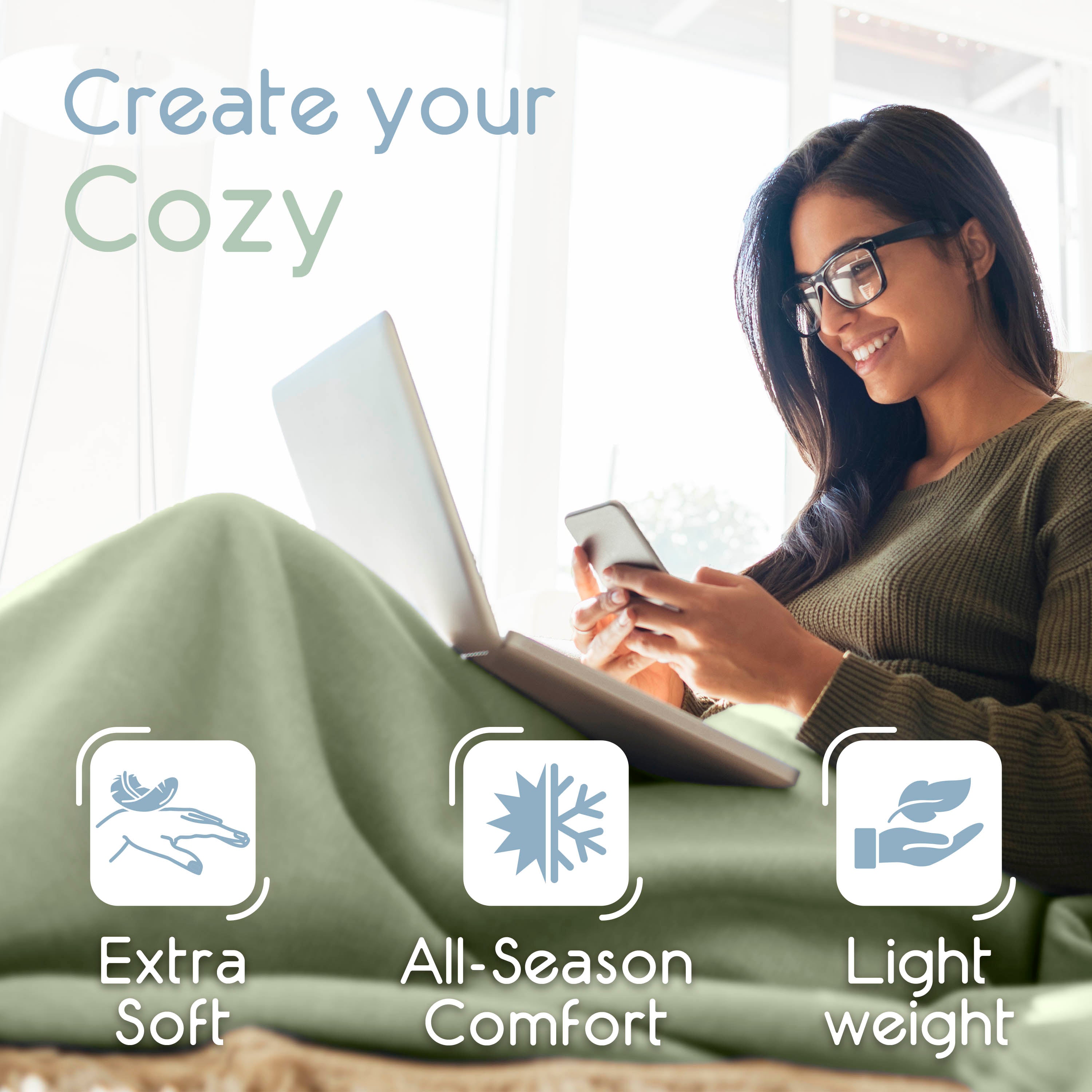 A woman sits on a couch, using a laptop and phone, covered with a light green micro fleece blanket.
