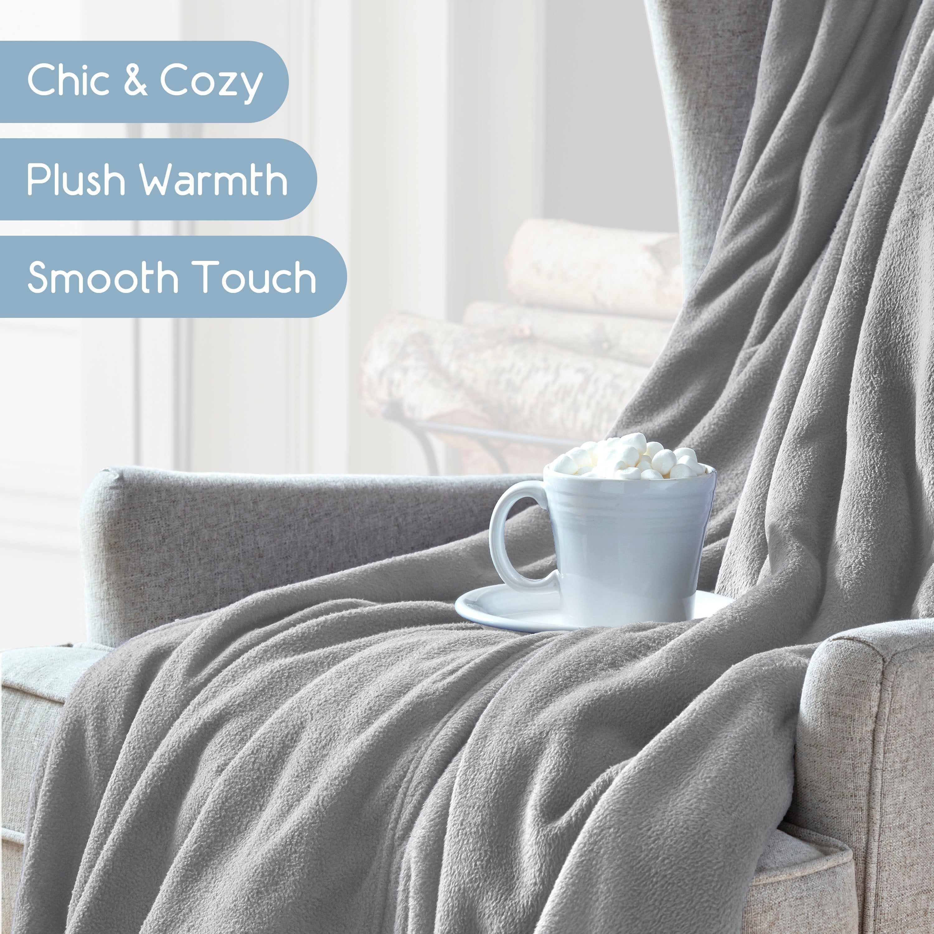 Gray microfleece blanket draped over an armchair with a cup of hot chocolate topped with marshmallows on a saucer.