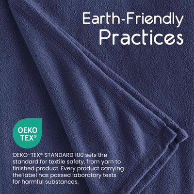 Dark blue micro fleece blanket with a folded edge, featuring Oeko-Tex certification information.