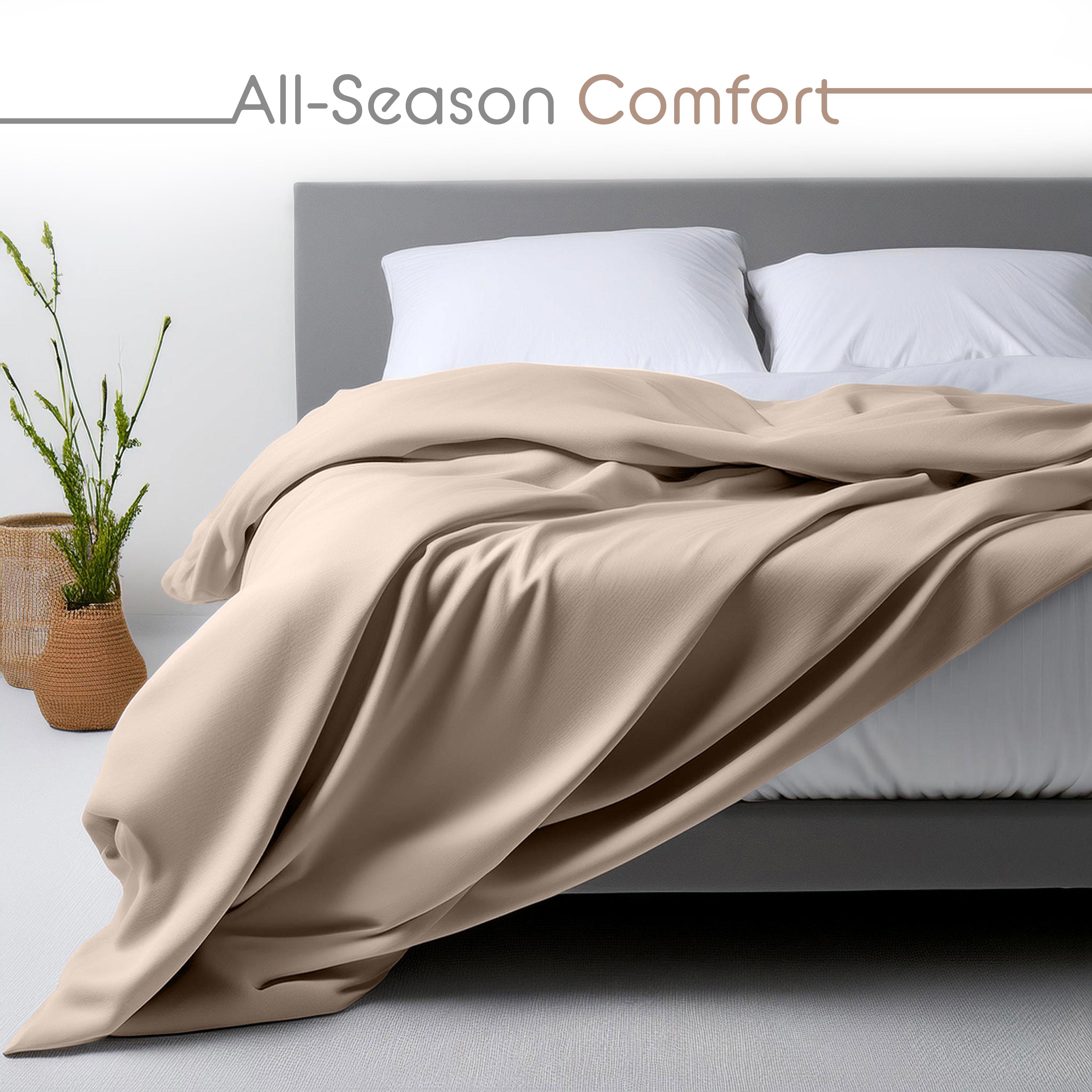 Beige snuggle sheet set draped over a bed with white pillows and a plant in a woven basket nearby.