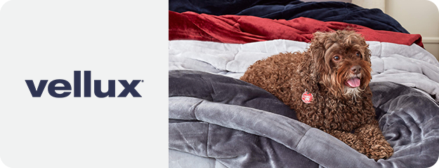 Dog lying on a Vellux blanket with the brand logo displayed.