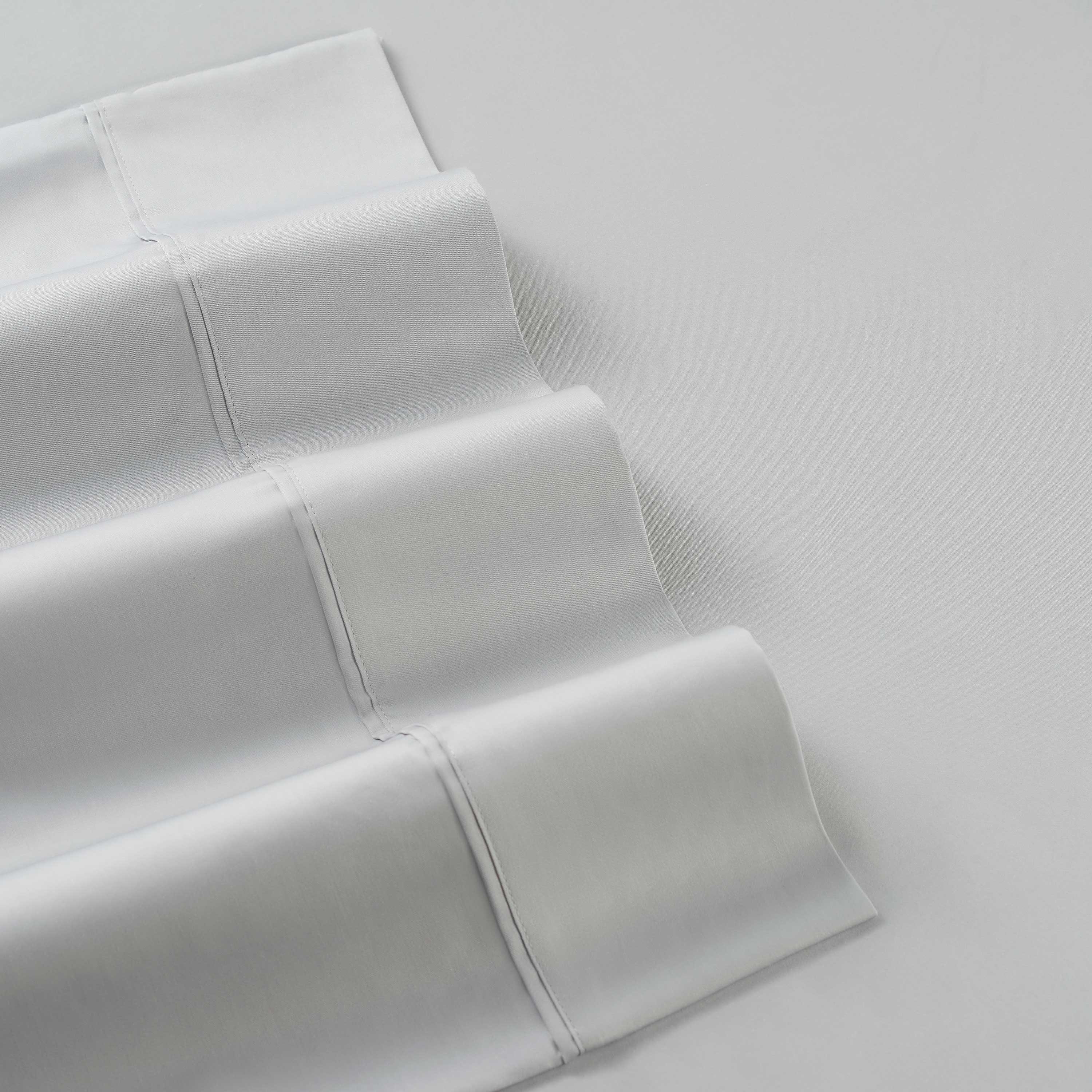 White cotton and Tencel sheet set with smooth, folded edges and visible stitching.