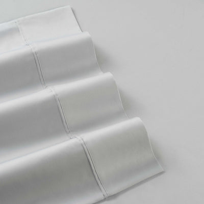 White cotton and Tencel sheet set with smooth, folded edges and visible stitching.