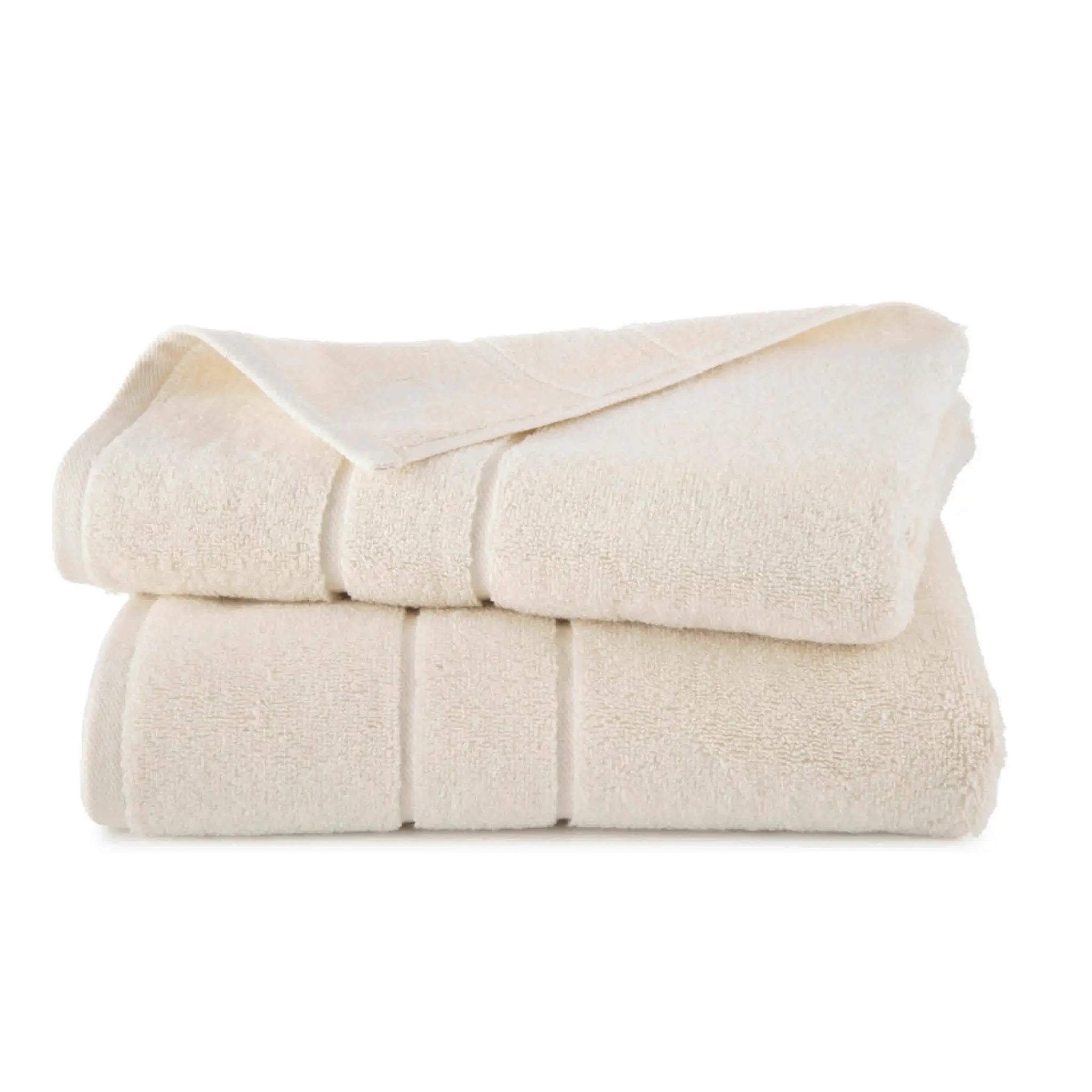 Folded ivory bath towel set on a white background