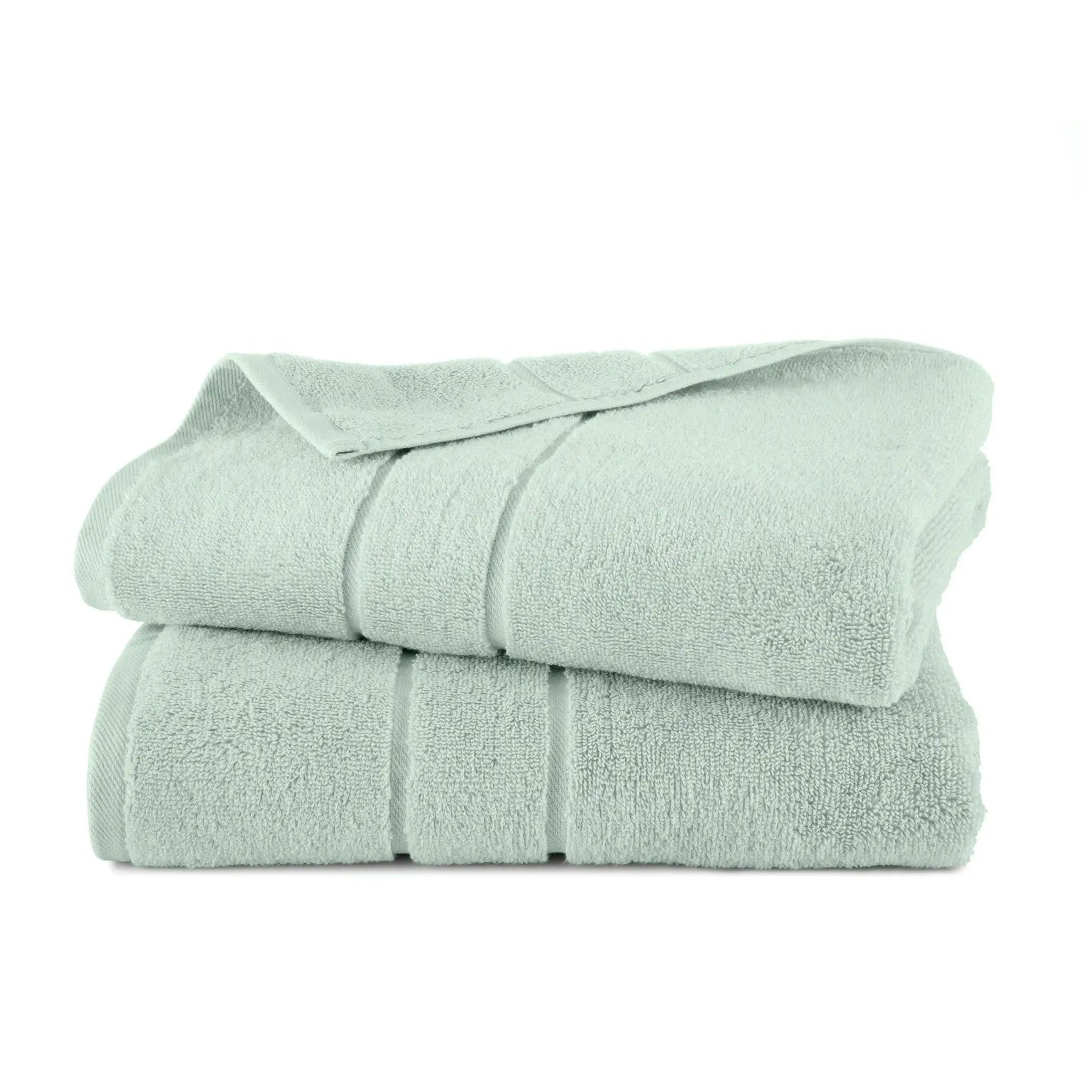Folded sage bath towel set on a white background