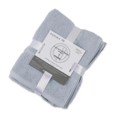 A folded set of two blue terry hand towels wrapped in white ribbons with a paper label that reads 'SUPIMA' and 'Clean Design by Martex'.