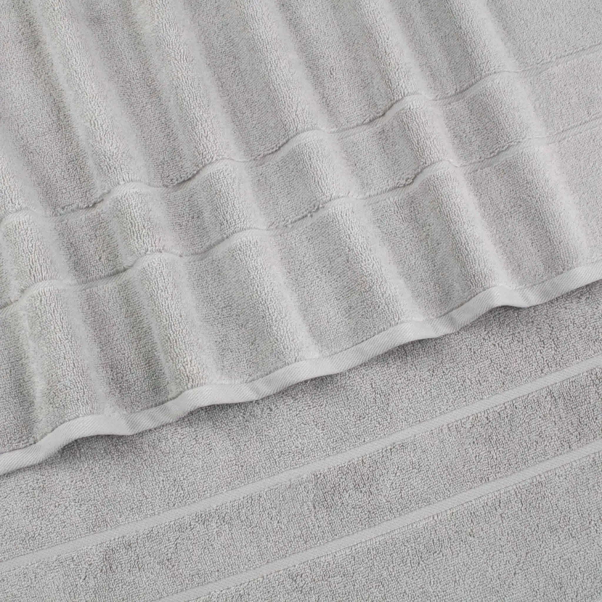 A close-up of a grey terry cloth hand towel with a textured striped pattern and folded edges.