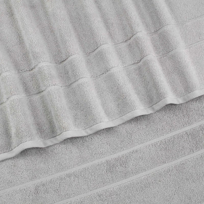 A close-up of a grey terry cloth hand towel with a textured striped pattern and folded edges.
