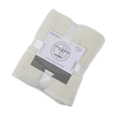 A folded set of two ivory terry hand towels wrapped in white ribbons with a paper label that reads 'SUPIMA' and 'Clean Design by Martex'.