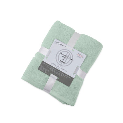 Folded light green hand towel with a label on a white background