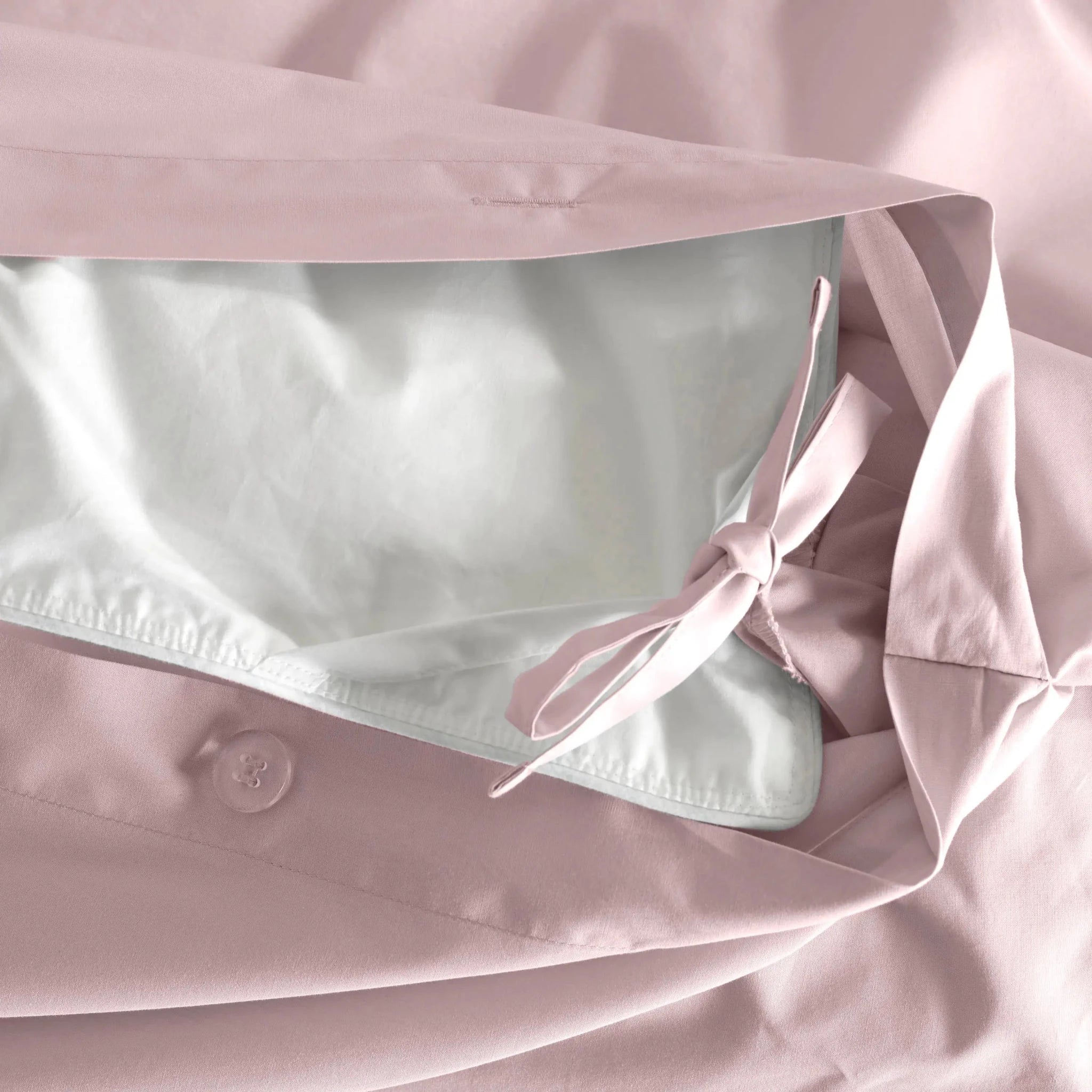 A close-up of a light pink pillow sham.