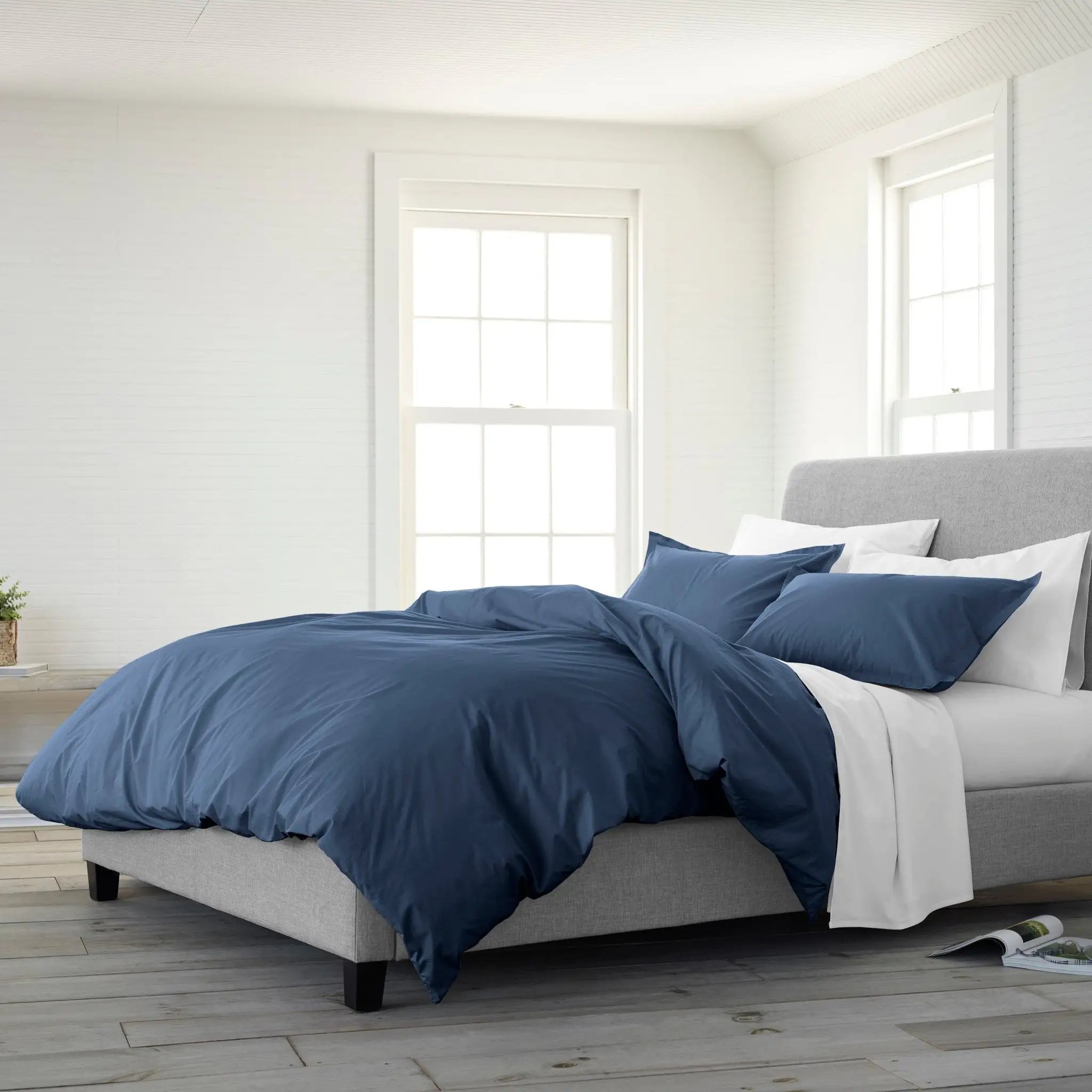 Bedroom with a bed featuring navy blue duvet set.