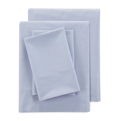 A stack of light blue-gray bedding sheets, including a flat sheet and pillowcases, neatly folded on a solid white background.