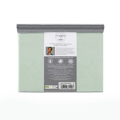 A folded sheet set in a light sage green color, sealed inside a clear plastic bag with a gray zipper and a large gray and white product label on the front.
