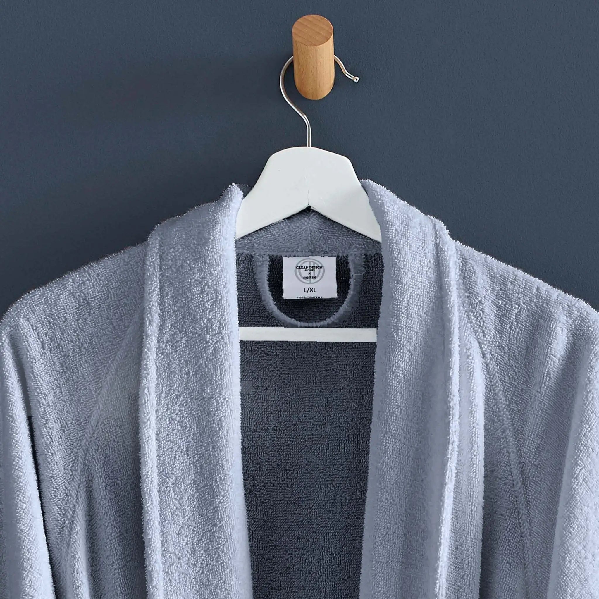 Blue robe draped over a hanger against a dark blue wall