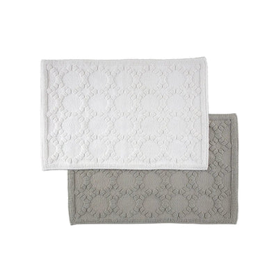Two rectangular bath rugs, stacked with one white mat on top of one gray mat, on a solid white background.