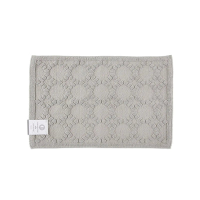 Gray textured bath rug with a brand label on a white background