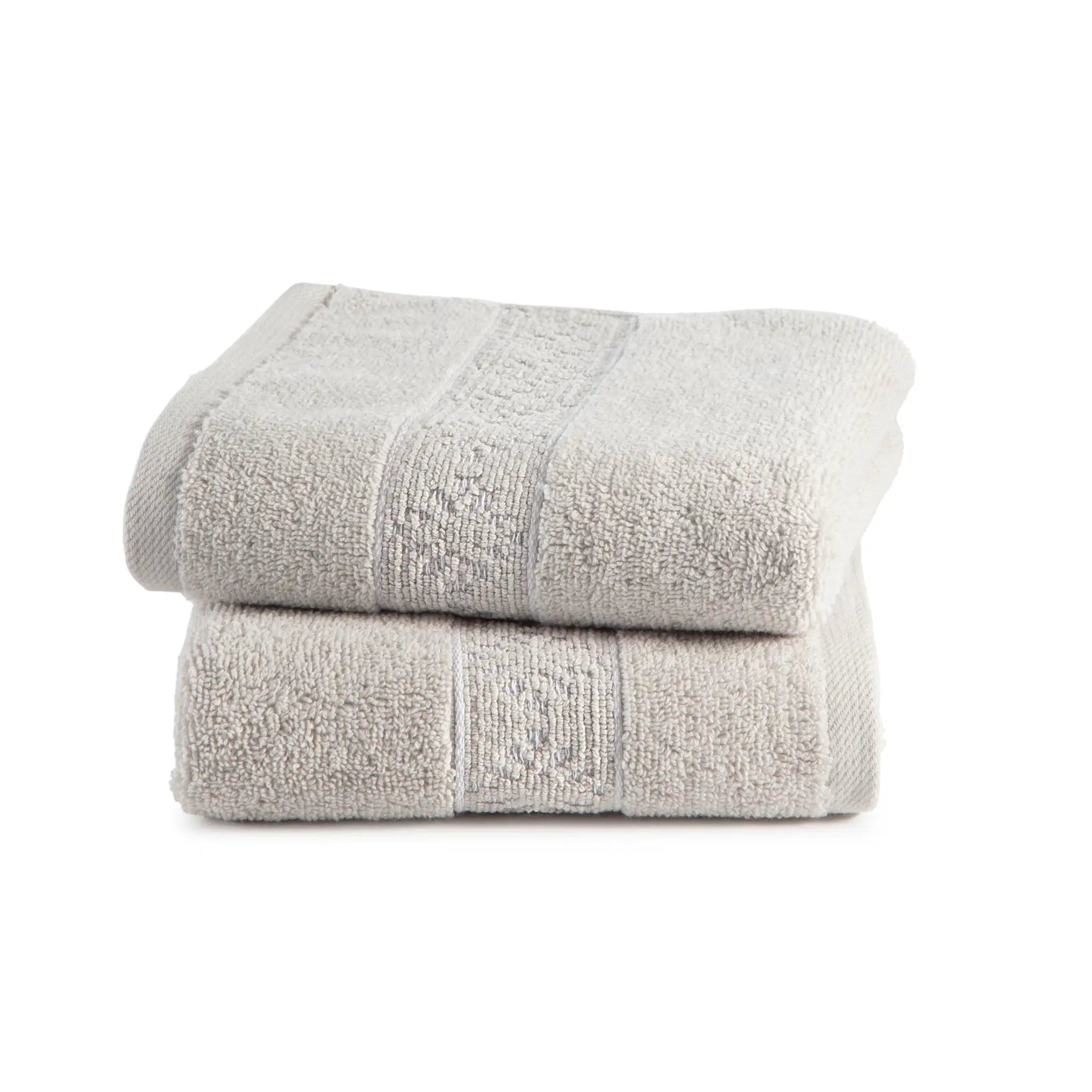 Two folded gray cotton hand towels stacked on a white background, showing a textured terry cloth surface and a subtle woven border detail.