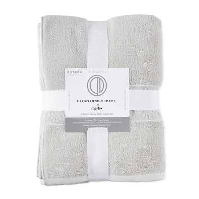 A folded 2-piece bath towel set in light gray terry cloth, wrapped with a white ribbon and a paper label from Clean Design Home x martex.