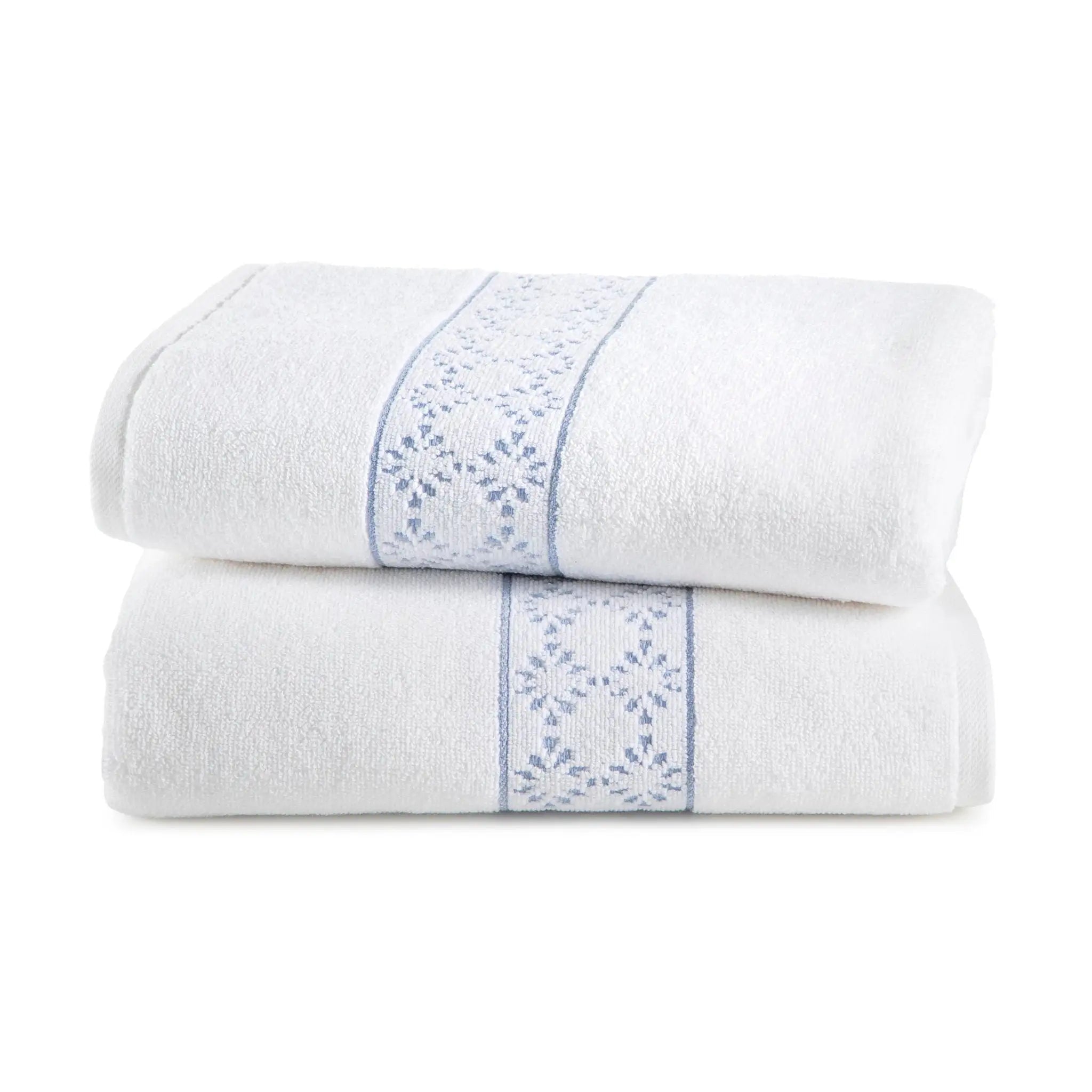 Two white bath towels with blue floral embroidery on a white background
