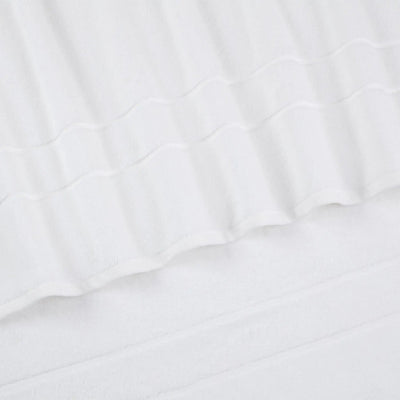 Close-up of a white textured fabric with a wavy stitched pattern and soft folds.