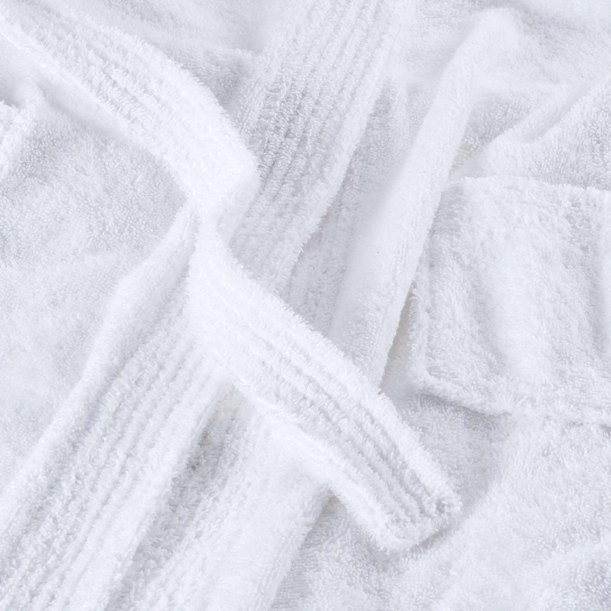A close-up of a white terry cloth robe with ribbed trim and a matching tie belt, showing the soft textured fabric details.