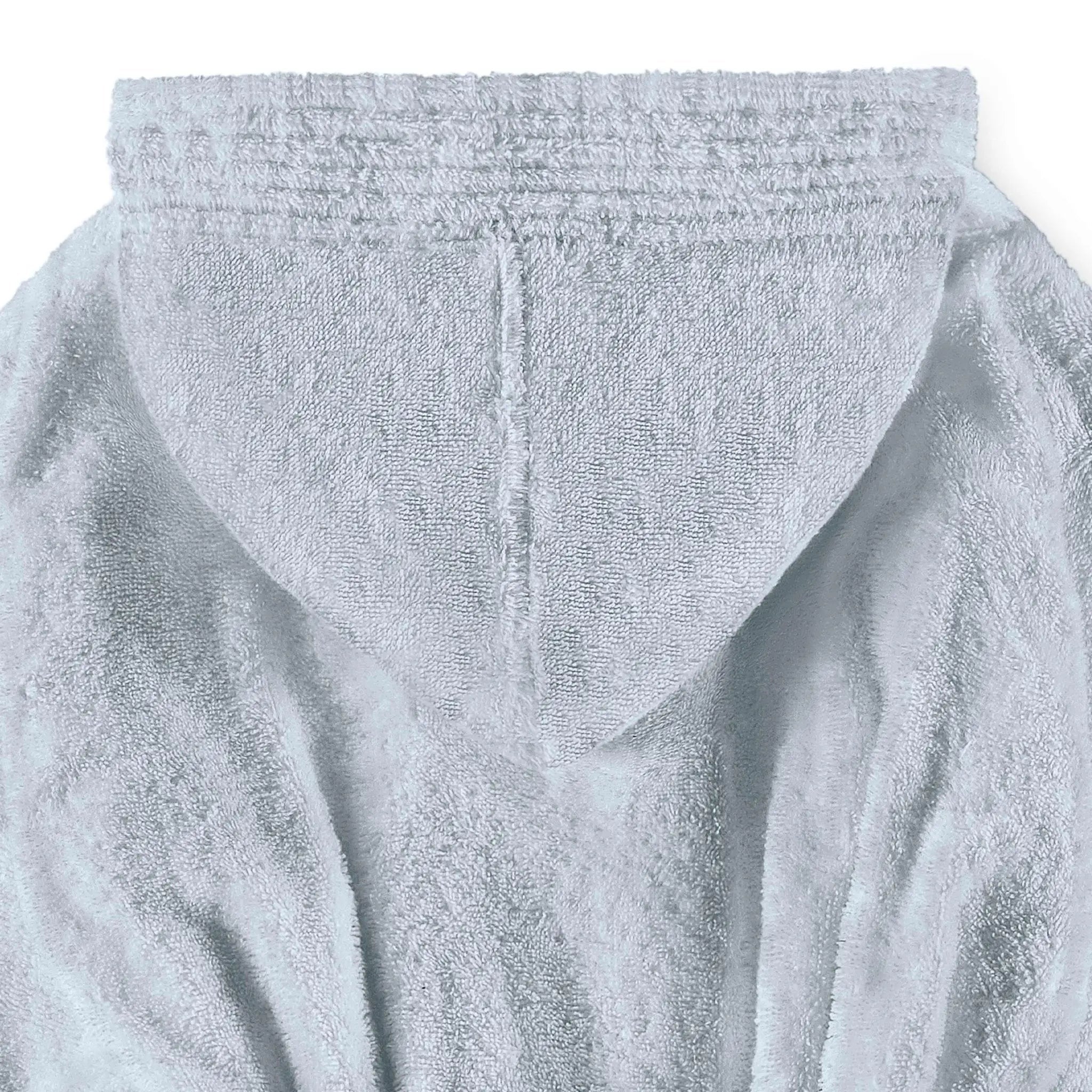 Close-up of a blue plush hooded robe or bathrobe fabric, showing the textured terry surface and hood opening against a plain white background.