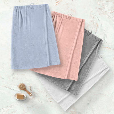 Four adult shower wraps in blue, pink, gray, and white, featuring an elastic waistband and soft texture.
