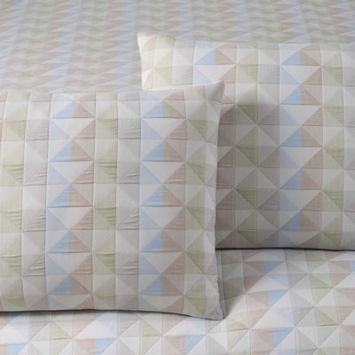 Comforter set featuring a geometric pattern of triangles in soft colors on a light background with matching pillow shams.