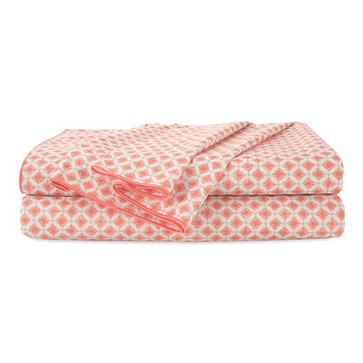 Folded orange patterned sheets on a white background