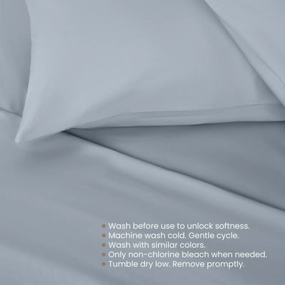 Light blue bedding fabric with a pillowcase and a list of care instructions printed at the bottom right.
