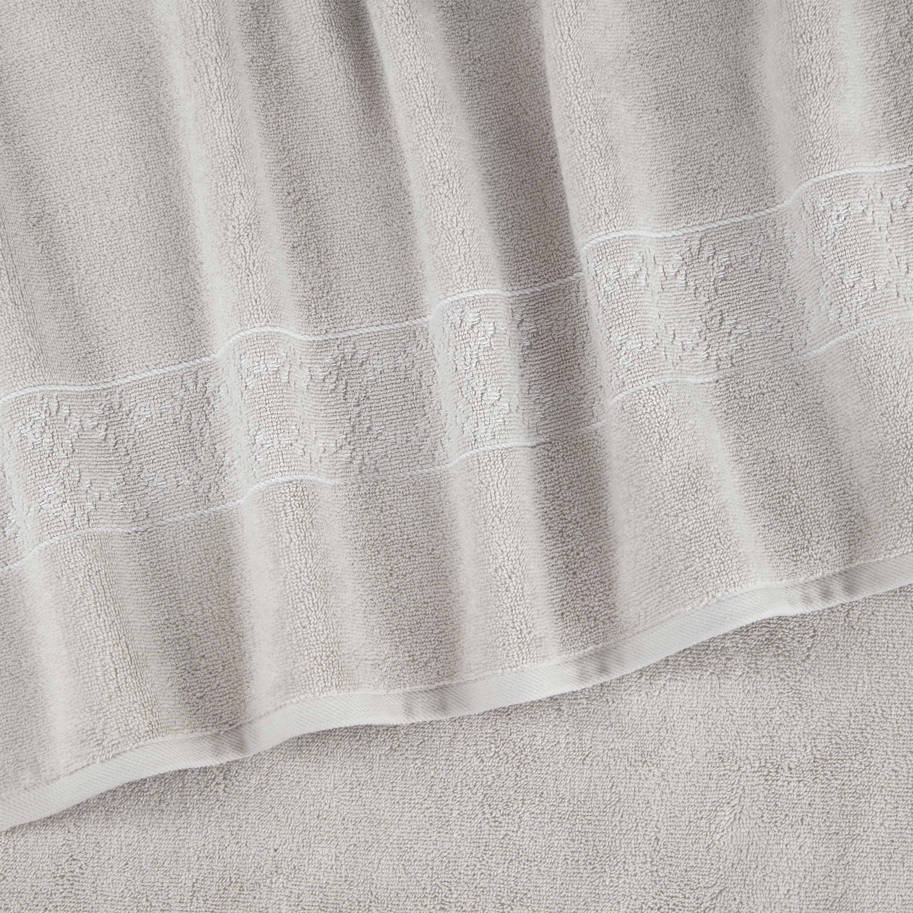 Light gray towel set with a textured pattern and decorative border.