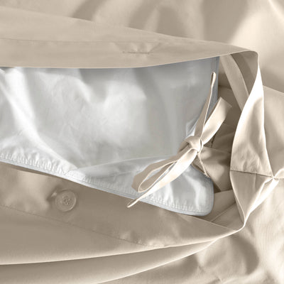 Duvet cover with a beige exterior and white interior, featuring a button closure and ties for securing the duvet.