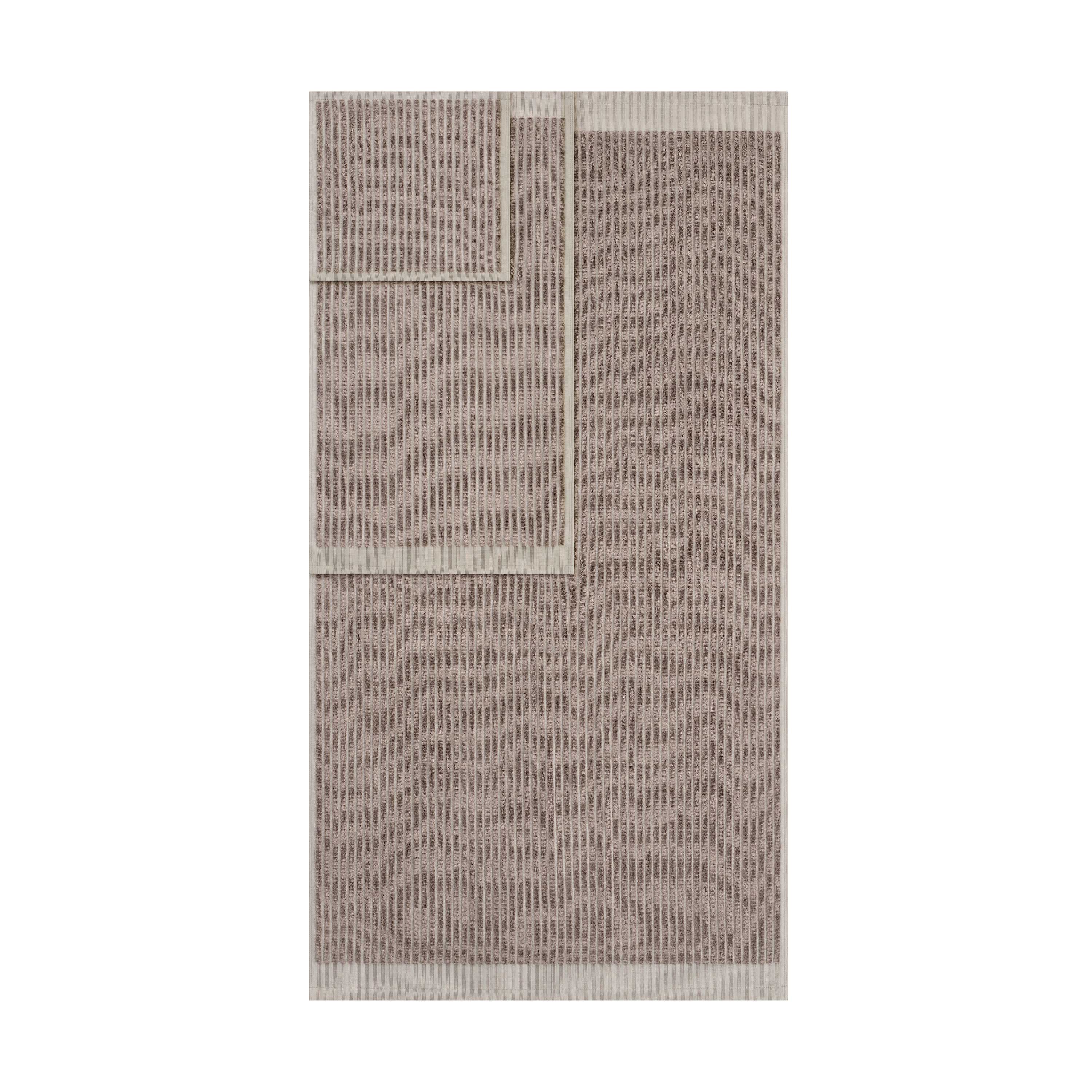 Two towels with a sculpted stripe design in a neutral color palette, featuring a contrasting border.