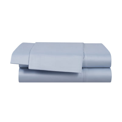 Solid light blue cotton and Tencel sheet set with a flat sheet and fitted sheet stacked neatly.