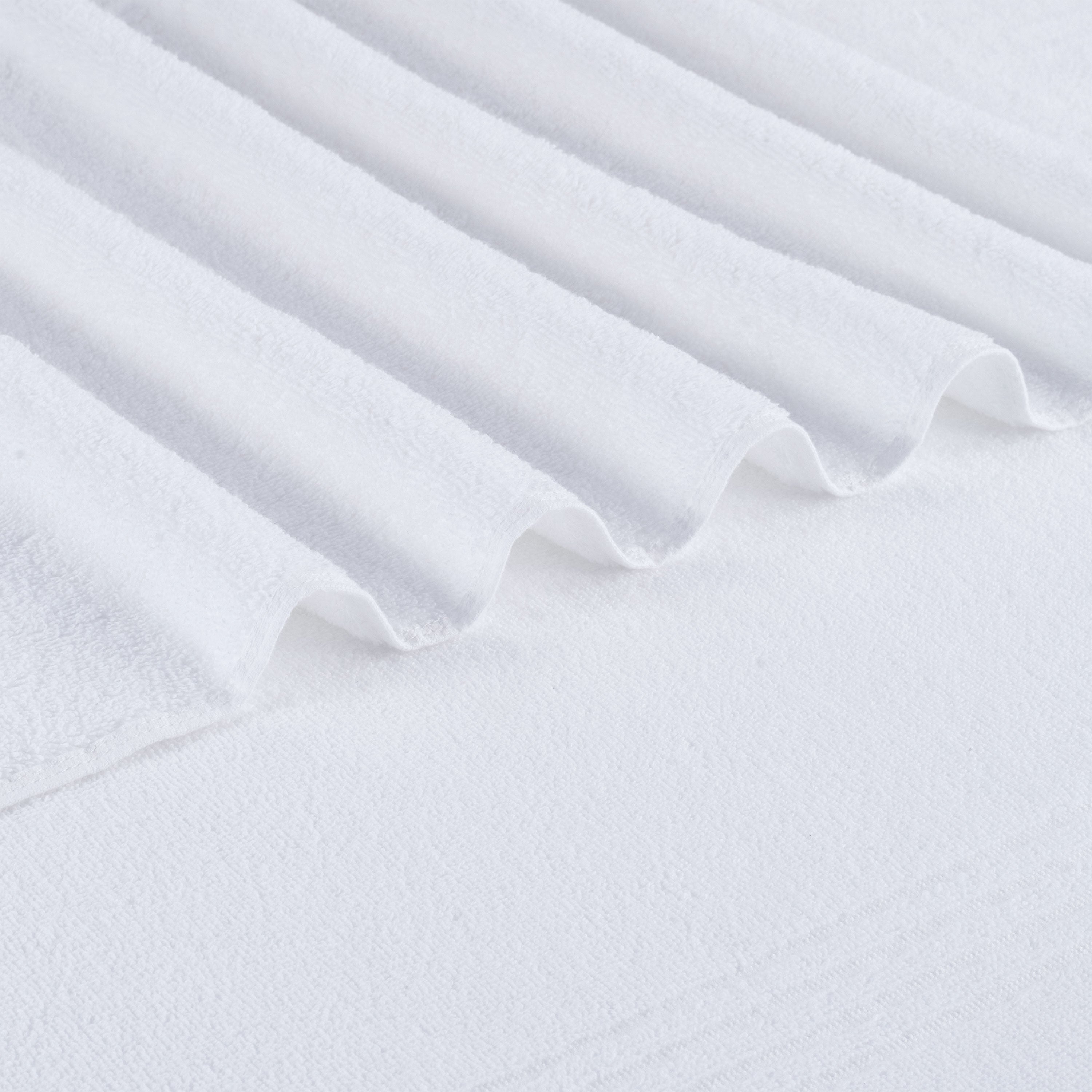 Oversized white bath towel with a textured, ribbed edge and soft, plush fabric.