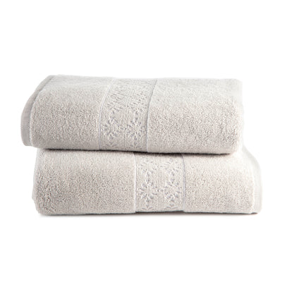 Two stacked towels in a light beige color with a textured design on the top towel.