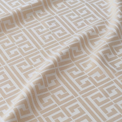Beige shower curtain with a geometric white pattern featuring interlocking shapes.