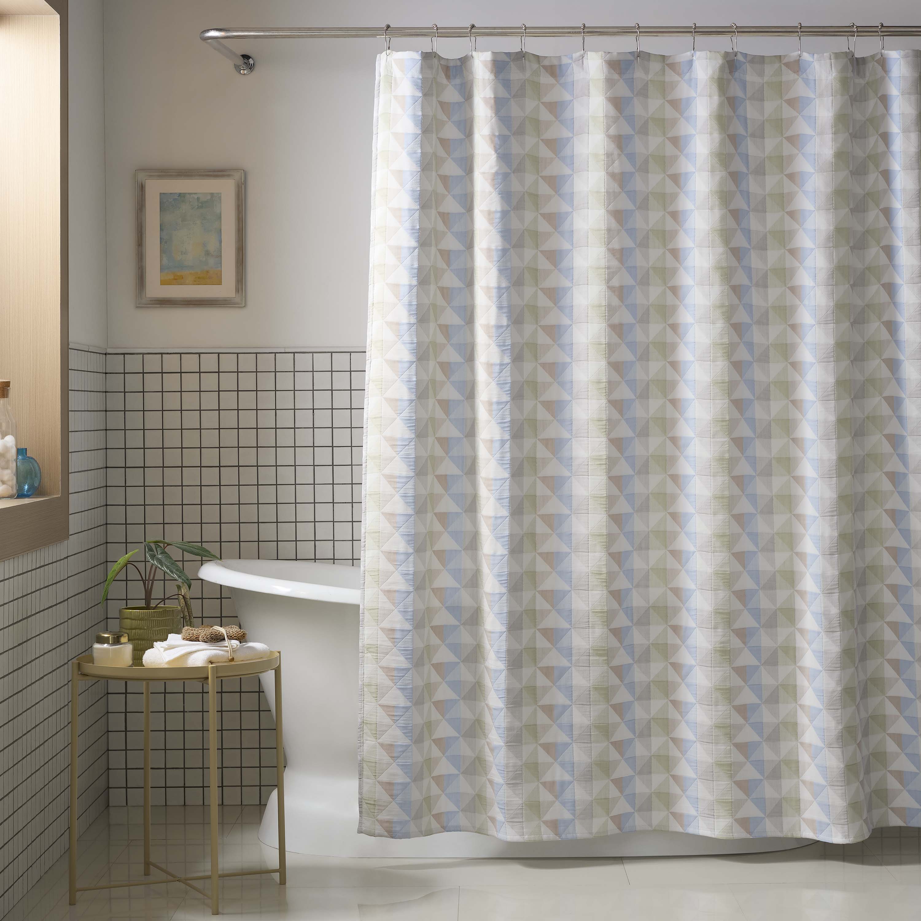 Shower curtain with a geometric pattern in soft colors, hanging in a modern bathroom setting.