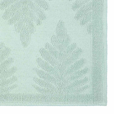 Light green bath rug featuring a fern ogee pattern with textured detailing and a bordered edge.